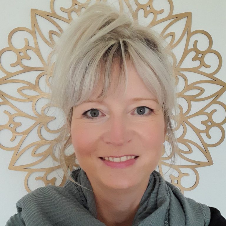 Daniela Gaßmann Frau mit blonder Frisur vor dunkelrotem Hintergrund